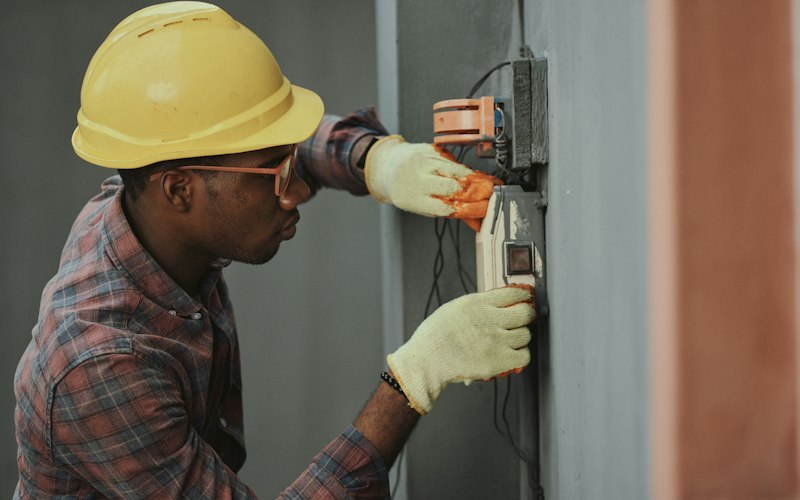 Technician in a hard hat servicing equipment
